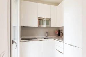 卡利亚里Emme Apartment IUN (Q8410)的白色的厨房配有白色橱柜和水槽