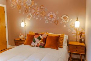 路易斯威尔Groovy Condo in the Vibrant NuLu District的卧室配有一张墙上鲜花的床