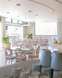 尼亚·卡利克拉提亚爱琴海蓝色海滩酒店 =的餐厅设有桌椅和大窗户。