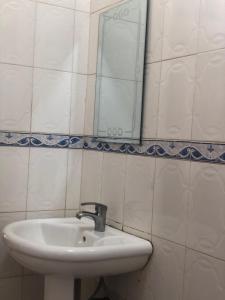 坦噶CBA Hotel的浴室设有水槽和墙上的镜子