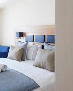 尼亚·卡利克拉提亚爱琴海蓝色海滩酒店 =的一张带白色枕头的大床