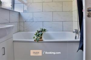 沃特福德Perfect For Contractors, Families, Business Stay, 2 Bed Apartment By HKM HOUSING Short Lets & Serviced Accommodation Watford的带浴缸的浴室和植物