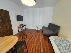 华沙FIRST -- Green Żoliborz apartment 3的客厅配有沙发、椅子和桌子