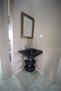 基加利OMX Hotel Remera的浴室设有黑色水槽和镜子