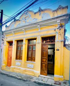 萨尔瓦多A Casa dos Mestres的黄色的建筑,设有木门和窗户
