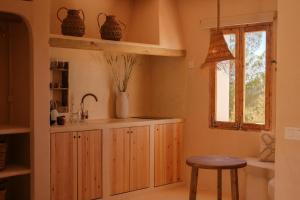 米乔尔海滩Estel Formentera的厨房配有木制橱柜和窗户。