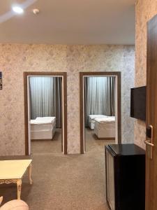 代胡克Lara Hotel的客房设有两张床、一台电视和两面镜子。