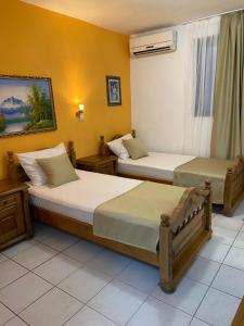 布德瓦库科酒店的黄色墙壁客房的两张床