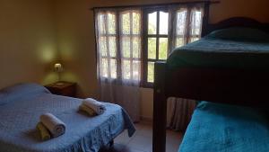 乌玛瓦卡La Rosarito的一间卧室设有两张床和窗户。