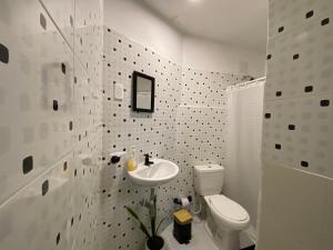 卡塔赫纳Habitación Cerca de aeropuerto的白色的浴室设有卫生间和水槽。