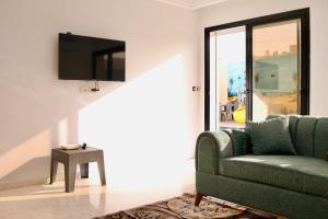 乌姆苏克Dar lamisse Djerba的客厅配有绿色沙发和电视
