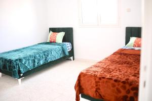 乌姆苏克Dar lamisse Djerba的一间卧室,配有两张床