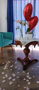 圣代佩德罗Pousada Sonho do Campo的一间房间,配有一张桌子,地板上摆放着红色座椅和鲜花