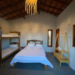 Ponta do AnelChalé dos ventos Macapá的一间卧室配有一张床和一个吊灯