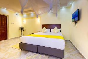 内罗毕Markson Hotel Kilimani的卧室配有一张大床,墙上配有电视