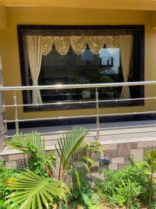 曼达莫尼Saikat Saranya Resort, #Mandarmoni #Beach的一座带窗帘和植物大窗户的建筑