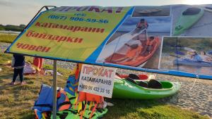 斯维季亚济Садиба For Rest的海滩上的标志,上面有皮艇和海报