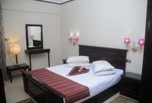 亚历山大New Siesta Hotel & Resort的一间卧室配有一张带白色床单和镜子的床