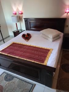 亚历山大New Siesta Hotel & Resort的一张木架床,上面有毯子