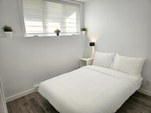 博普雷Le 4 Saisons 4的白色的窗户客房内的一张白色的床