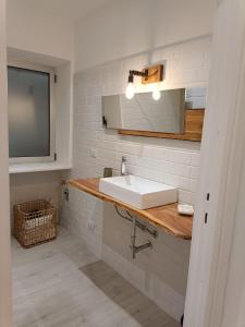 阿尔盖罗利莫尼公寓的浴室设有白色水槽和镜子