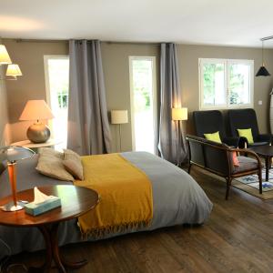 贝尔热拉克La Maison des Hérissons的卧室配有一张床和一张桌子及椅子