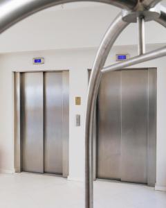 尼亚·卡利克拉提亚爱琴海蓝色海滩酒店 =的两部电梯,楼内有金属门