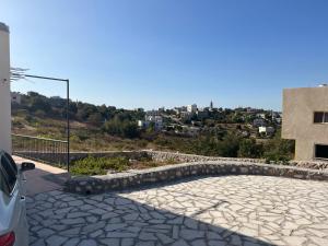 安曼Nice chalet in front of Ajloun mountains的停在大楼前的汽车