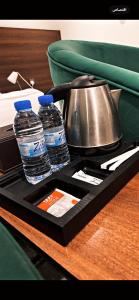 Sīdī Ḩamzahأضواء الشرق للشقق الفندقية Adwaa Al Sharq Hotel Apartments的托盘,内含2瓶水和茶壶
