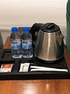 Sīdī Ḩamzahأضواء الشرق للشقق الفندقية Adwaa Al Sharq Hotel Apartments的茶壶和托盘上的两瓶水