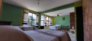 Huautla de JiménezCasa Cejota的一间医院房间,设有三张床和绿色的墙壁