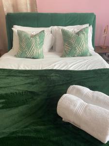 Corfe MullenThe Lily Pad的一张绿色和白色的床,配有枕头