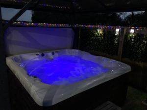 LincolnshireSpacious Lodge With Hot Tub的后院的按摩浴缸配有灯