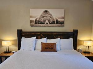Thompson FallsRiverfront Motel & Cabins的卧室配有一张挂着熊照片的床