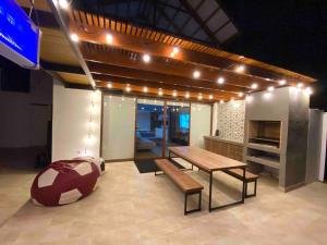San PabloCamelia Chincha® Hermosa Casa de Playa y Campo的一间设有桌子、长凳和灯的房间