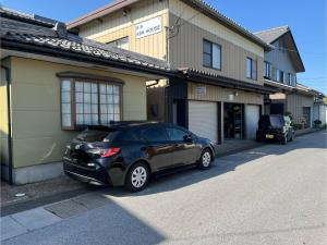 长滨市Minpaku KEN HOUSE - Vacation STAY 60980v的停在大楼前的一辆黑色汽车