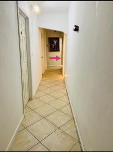 迈阿密B3 Best Value on Private Bedroom with Private Bathroom in Little Havana, Miami的墙上有粉红色箭头的走廊