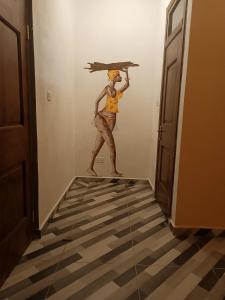 BusuaPalm Grove lodge的把一把伞放在走廊上的女人的画