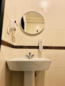 第聂伯罗Отель Ренессанс的浴室水槽、镜子和电话