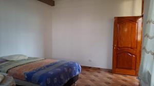 马尔多纳多港Disfruta la Selva Peruana Pto.M的一间卧室配有一张床和一扇木门