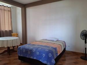 马尔多纳多港Disfruta la Selva Peruana Pto.M的一间卧室配有一张床和一张带风扇的桌子。