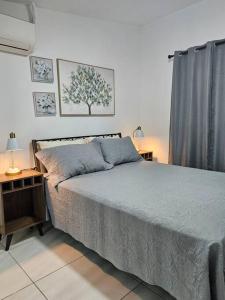 巴拿马城Loft Moderno y Tranquilo # 7的一间卧室配有一张床和一张带台灯的桌子