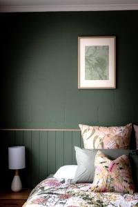 剑桥Twelve 30 - easy airport access的一间绿色卧室,配有一张床和墙上的照片