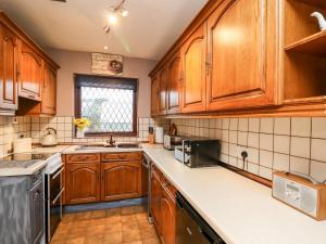 卡马森Llys-Yr-Onnen的厨房配有木制橱柜和白色台面