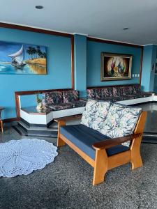 瓜拉派瑞Hotel Quatro Estações的带沙发和蓝色墙壁的客厅