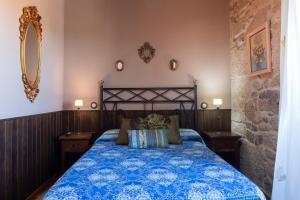 O PindoCasa A Laxe的一间卧室配有一张带蓝色棉被的床
