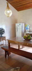 巴拉格兰德Chalé em Maraú pertinho da praia的厨房配有木桌和冰箱。