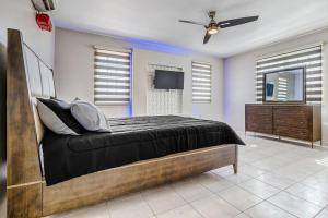瓜亚马DC Luxury House的一间卧室配有一张床、一台电视和一个梳妆台
