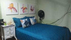 蒙加瓜Apto na praia do Centro Mongaguá ~ Ótima Localização的一间卧室配有蓝色的床和梳妆台