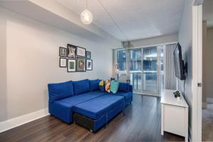 多伦多Condo in the heart of Downtown Toronto!的客厅设有蓝色沙发,配有电视